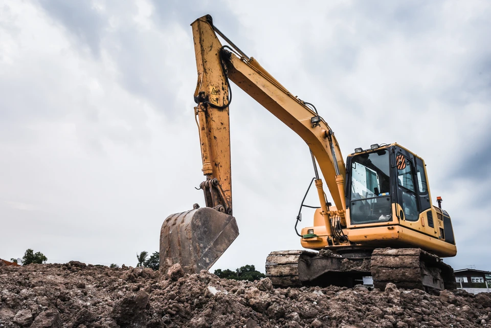Chantier de construction résidentielle avec dalle béton coulée récemment et tranchée d'évacuation creusée