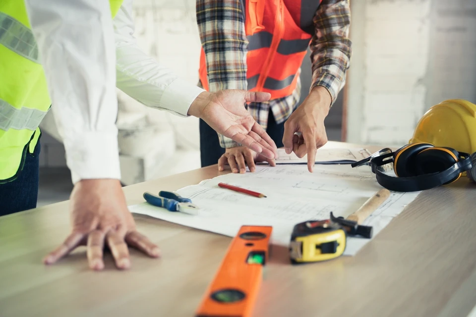Deux ingénieurs discutent de l'avancement des travaux sur un chantier, examinent les abonnements et collaborent à l'élaboration et à la conception du projet